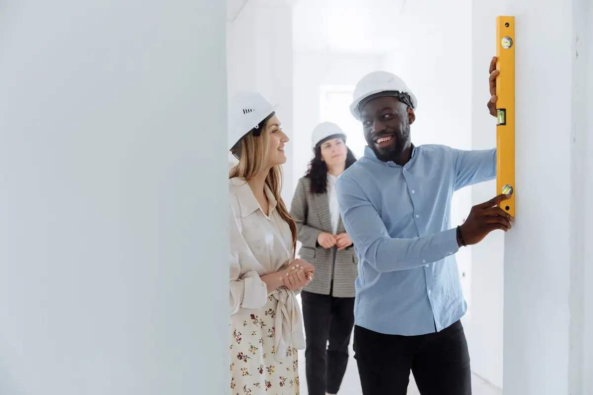 Professionals checking an interior wall with a spirit level during a property inspection